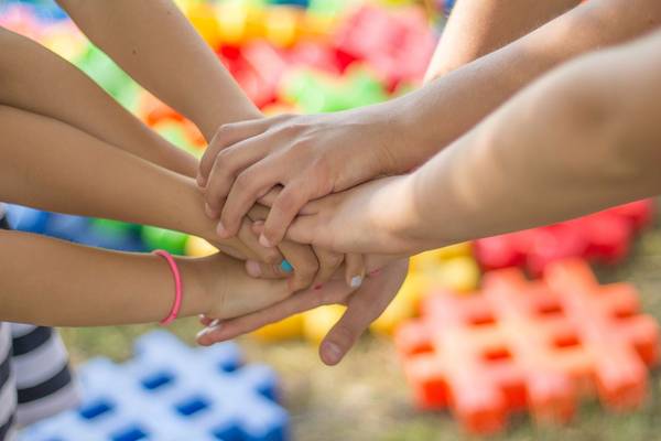 Quelle: pixabay.de / jarmoluk, https://pixabay.com/de/photos/h%c3%a4nde-freundschaft-freunde-kinder-2847508/, Freie kommerzielle Nutzung Kein Bildnachweis nötig Hände stapeln sich für Zusammenhalt